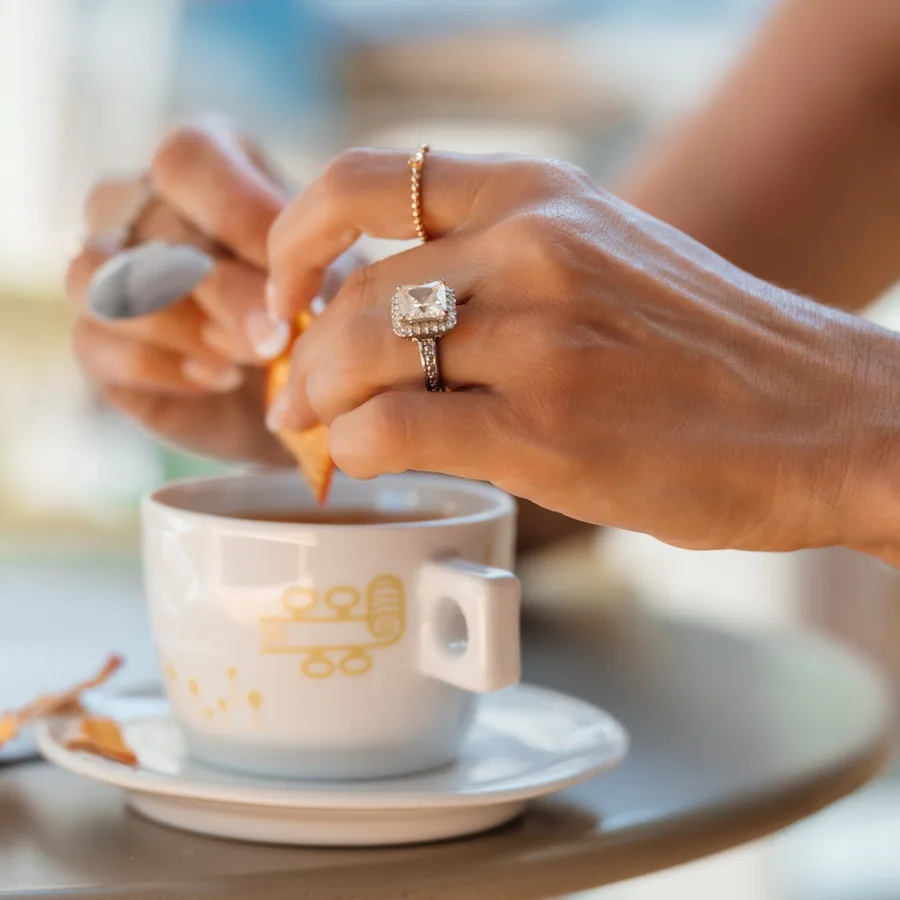 Hands stirring an espresso at a Sicilian cafe table
